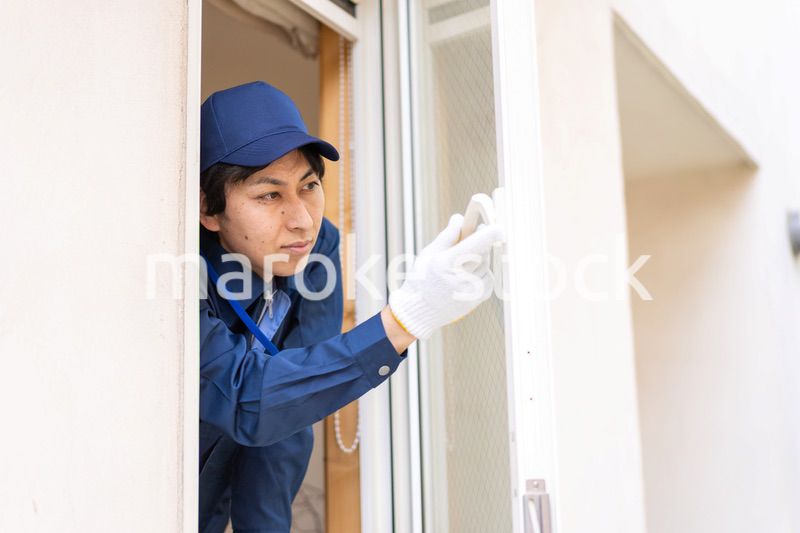窓のメンテナンスをする技術スタッフ