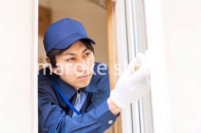 窓のメンテナンスをする技術スタッフ