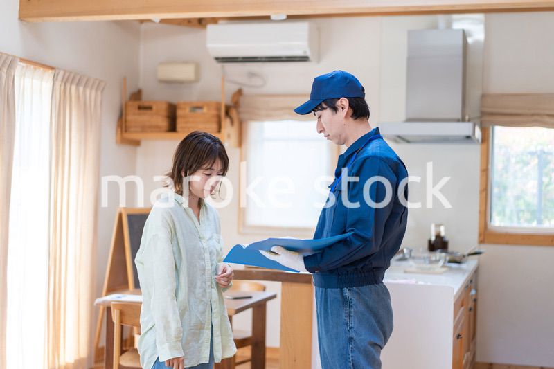 業者に家のメンテナンスをしてもらう女性