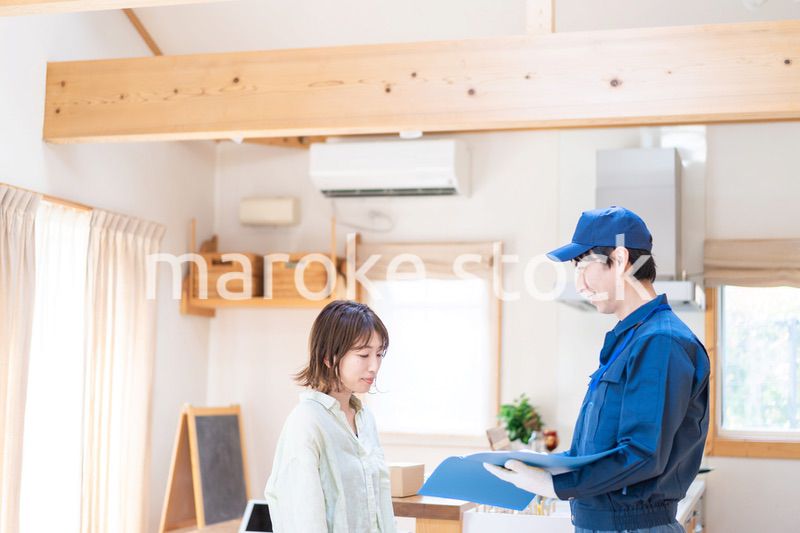 業者に家のメンテナンスをしてもらう女性