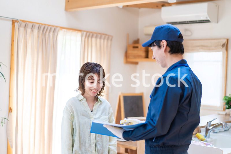 業者に家のメンテナンスをしてもらう女性