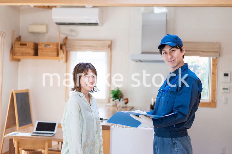 業者に家のメンテナンスをしてもらう女性
