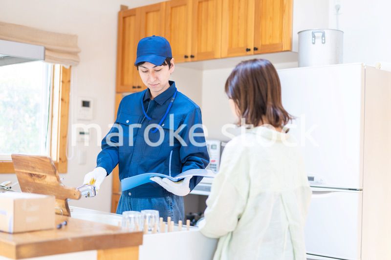 業者に家のメンテナンスをしてもらう女性