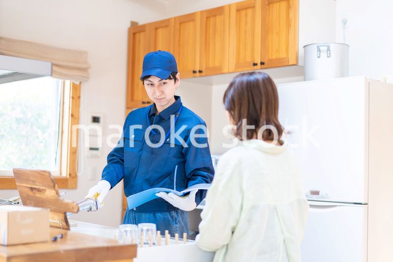 業者に家のメンテナンスをしてもらう女性