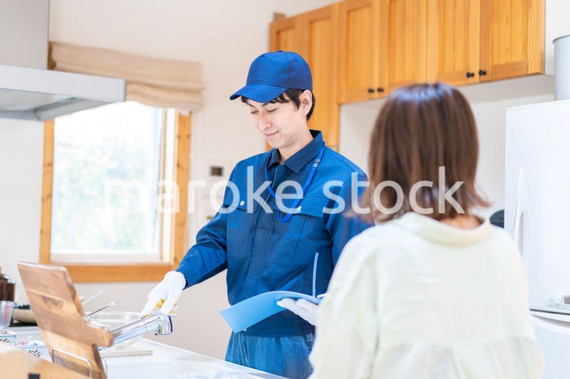 業者に家のメンテナンスをしてもらう女性