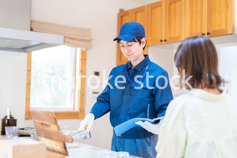 業者に家のメンテナンスをしてもらう女性