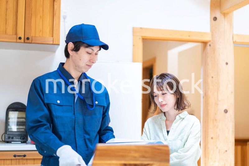 業者に家のメンテナンスをしてもらう女性