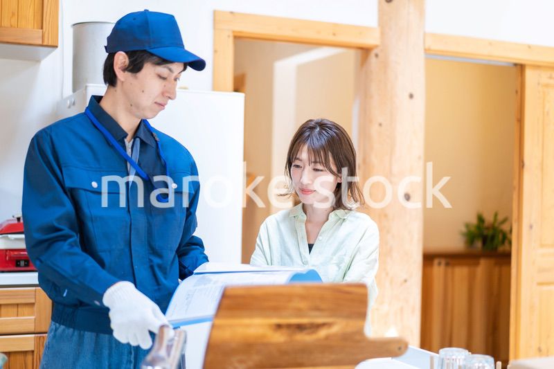業者に家のメンテナンスをしてもらう女性