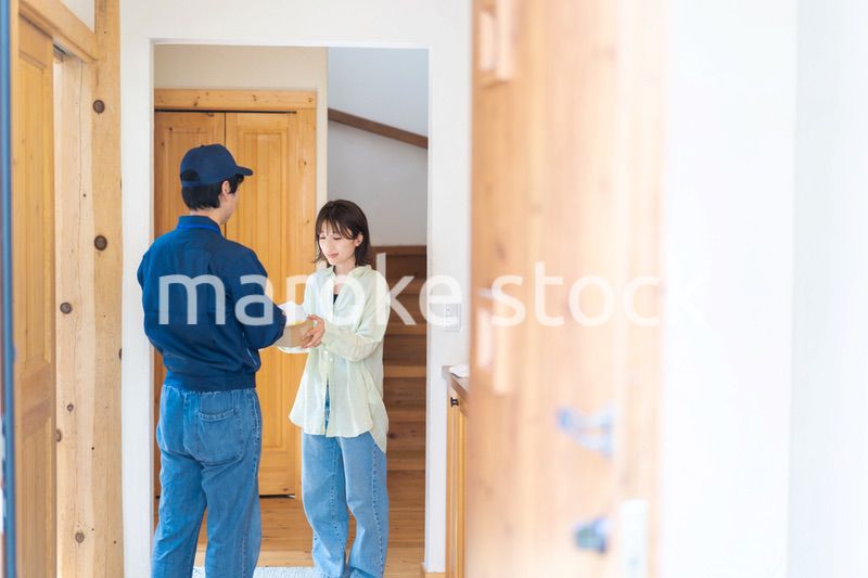 宅配便・デリバリーを受け取る若い女性