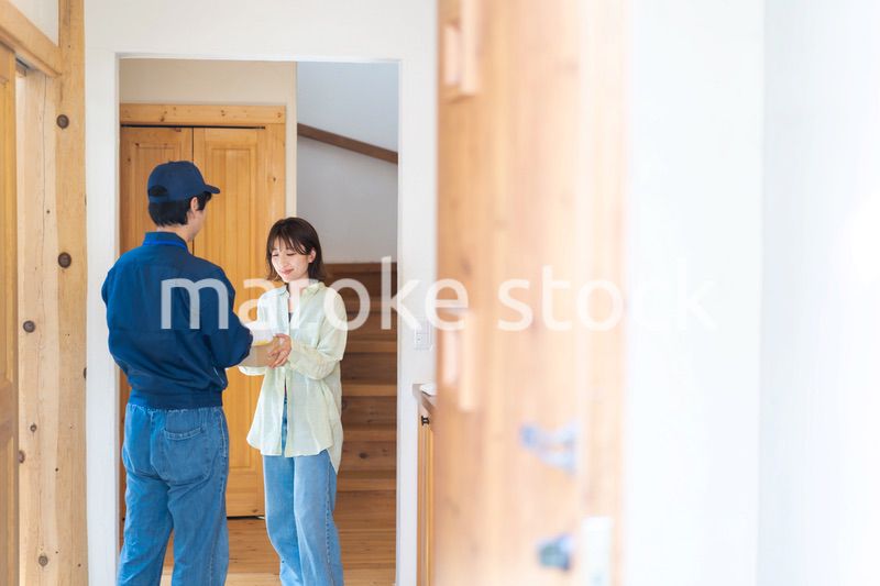 宅配便・デリバリーを受け取る若い女性