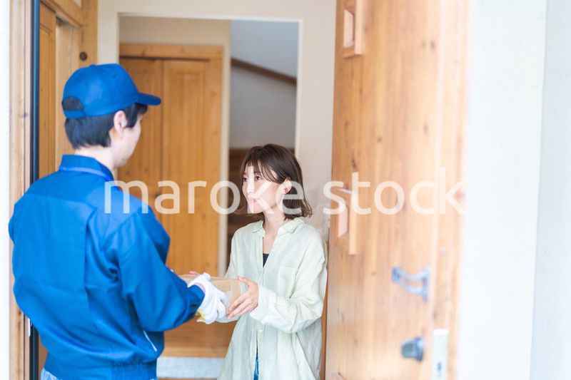 宅配便・デリバリーを受け取る若い女性