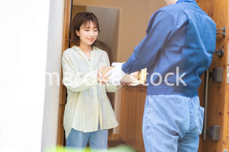 宅配便・デリバリーを受け取る若い女性