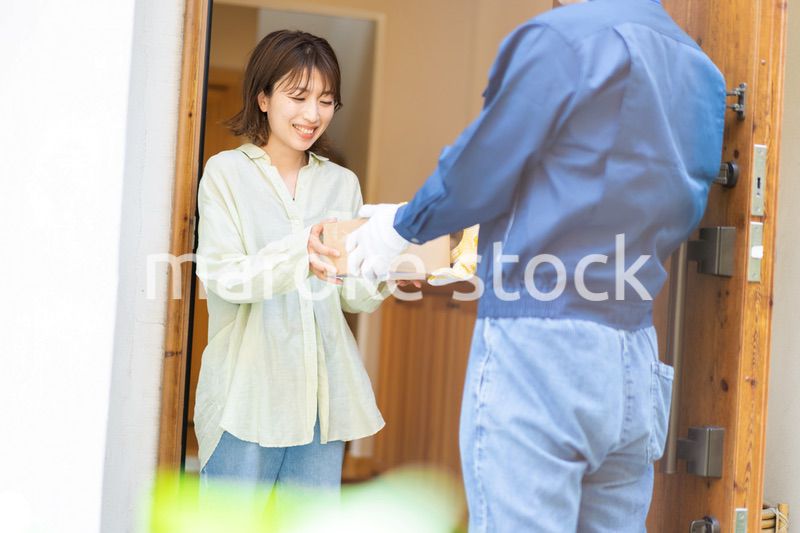 宅配便・デリバリーを受け取る若い女性