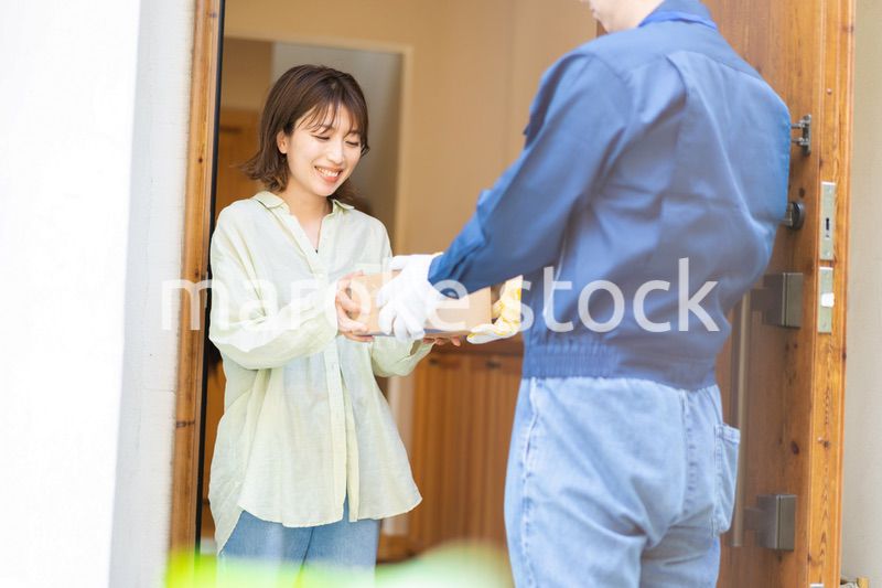 宅配便・デリバリーを受け取る若い女性