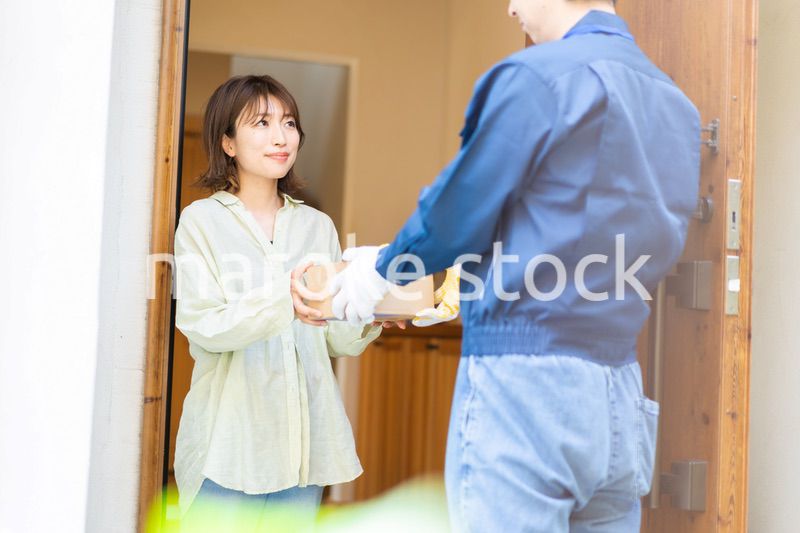 宅配便・デリバリーを受け取る若い女性