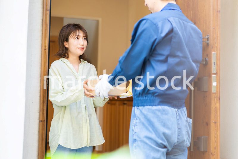 宅配便・デリバリーを受け取る若い女性