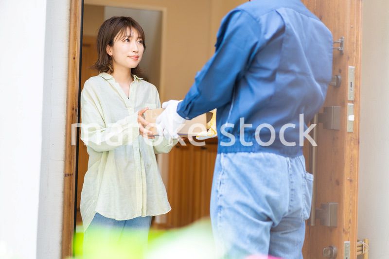 宅配便・デリバリーを受け取る若い女性
