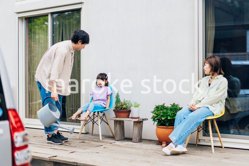 自宅の庭でリラックスをする女の子と家族