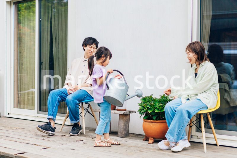 自宅の庭でリラックスをする女の子と家族