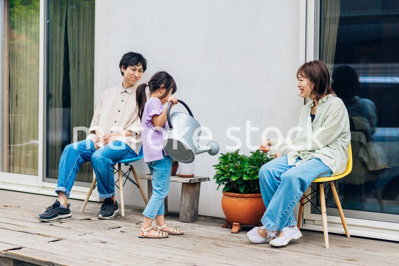 自宅の庭でリラックスをする女の子と家族