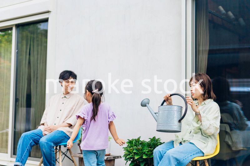 自宅の庭でリラックスをする女の子と家族