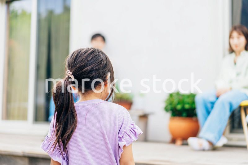 自宅の庭でリラックスをする女の子と家族