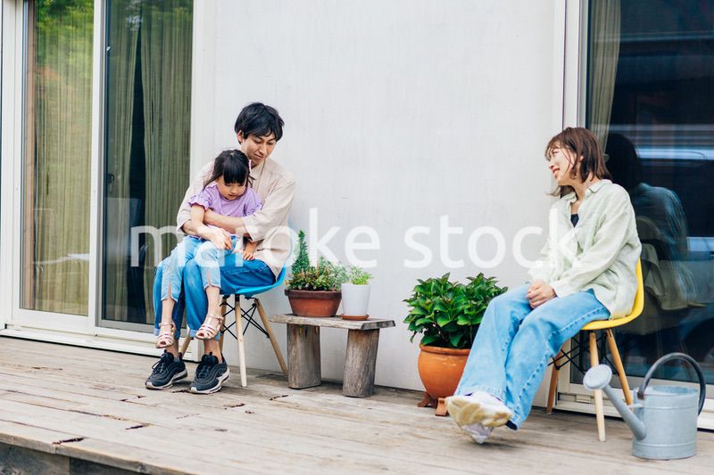 自宅の庭でリラックスをする女の子と家族