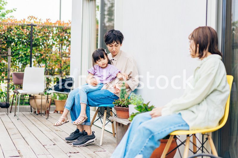 自宅の庭でリラックスをする女の子と家族