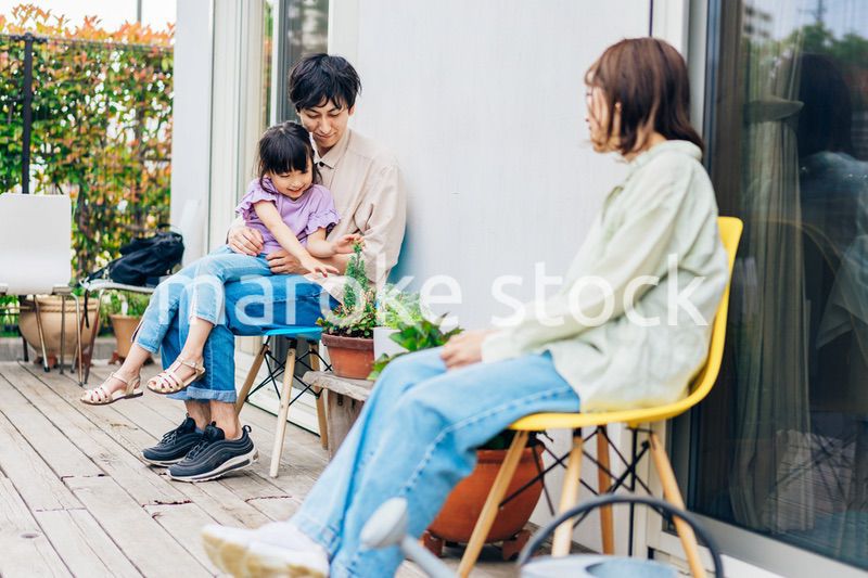 自宅の庭でリラックスをする女の子と家族