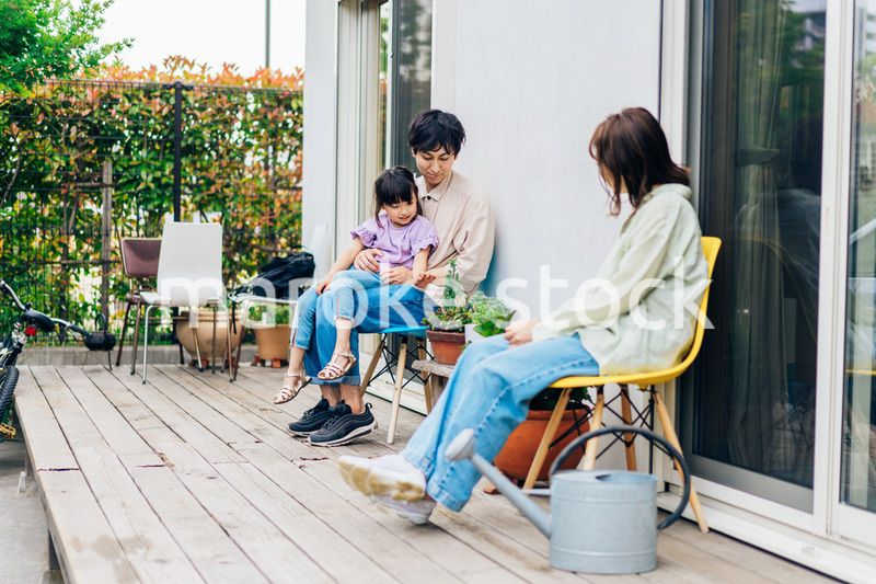 自宅の庭でリラックスをする女の子と家族