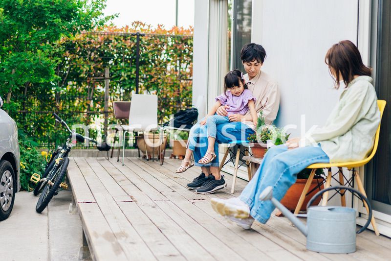 自宅の庭でリラックスをする女の子と家族