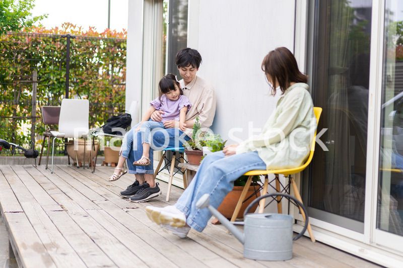 自宅の庭でリラックスをする女の子と家族