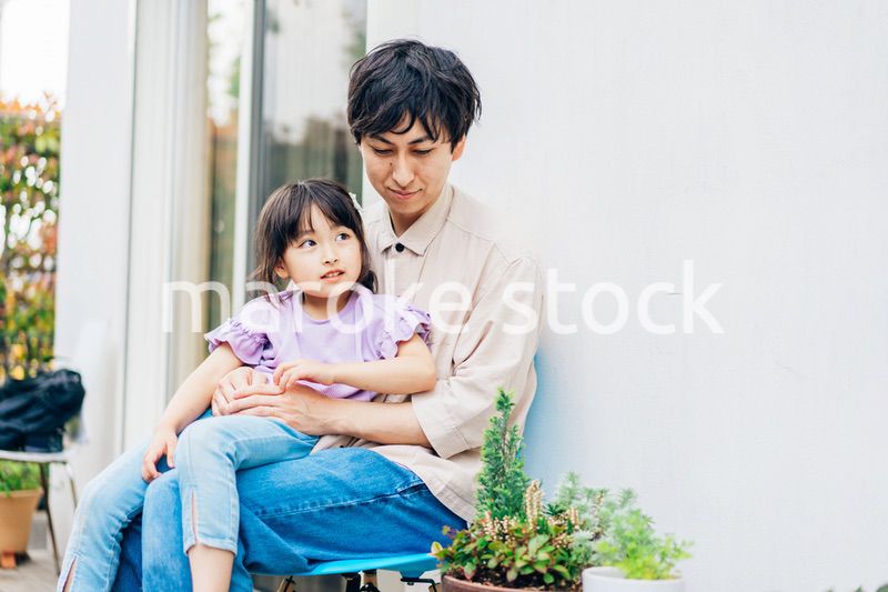 自宅の庭でリラックスをする女の子と家族