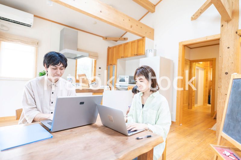 テレワークをする夫婦と子供