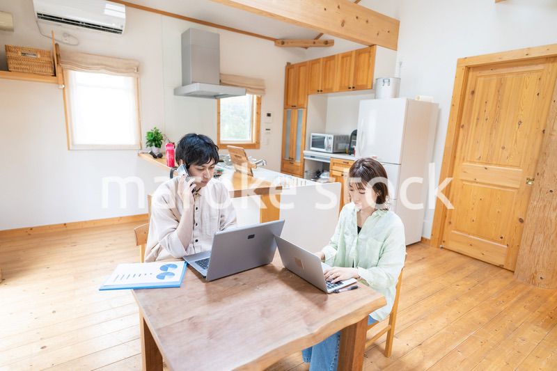 テレワークをする夫婦と子供