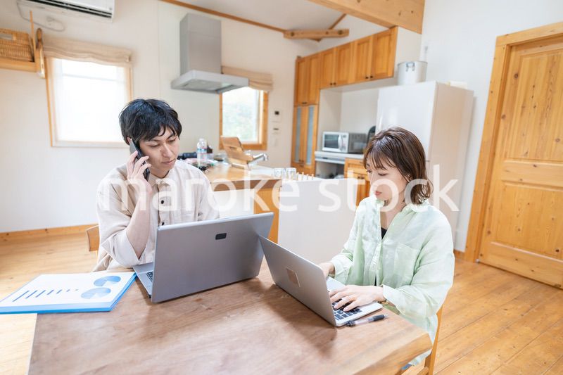 テレワークをする夫婦と子供