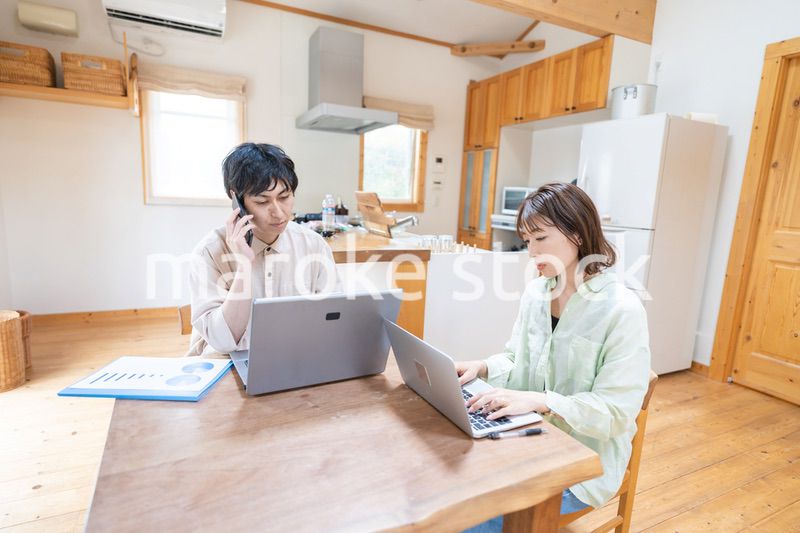 テレワークをする夫婦と子供