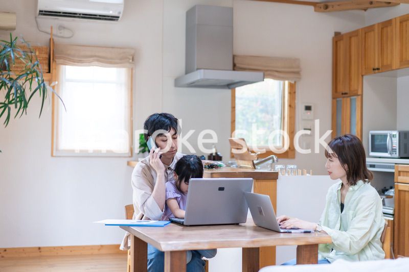 テレワークをする夫婦と子供