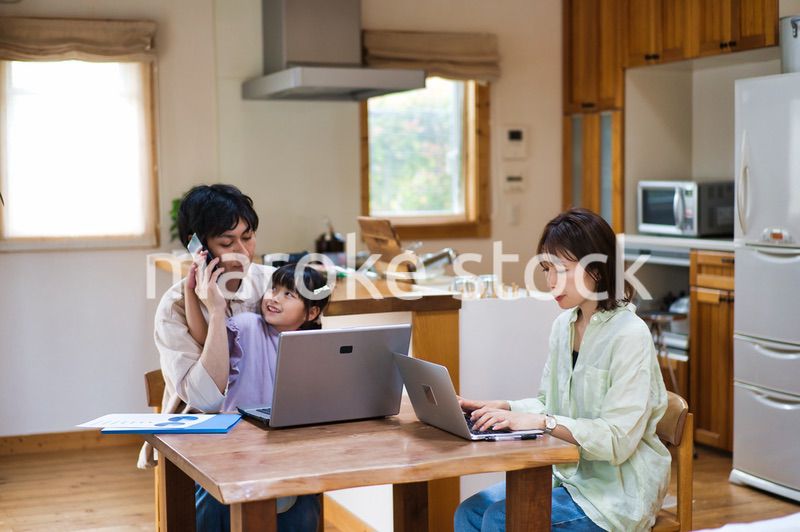 テレワークをする大人と家にいる子ども