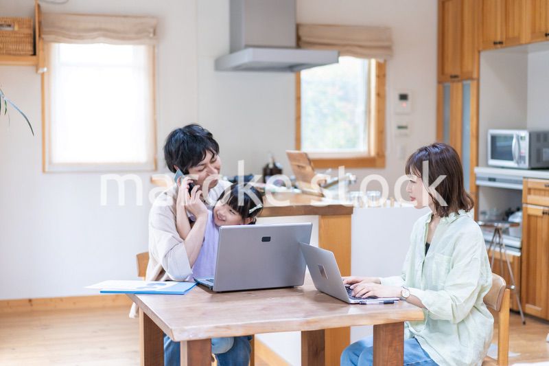 テレワークをする夫婦と子供