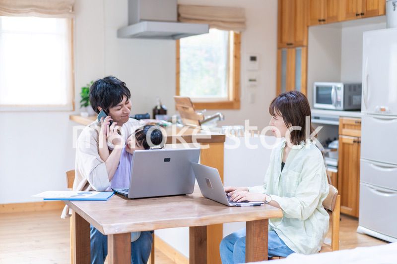 テレワークをする夫婦と子供