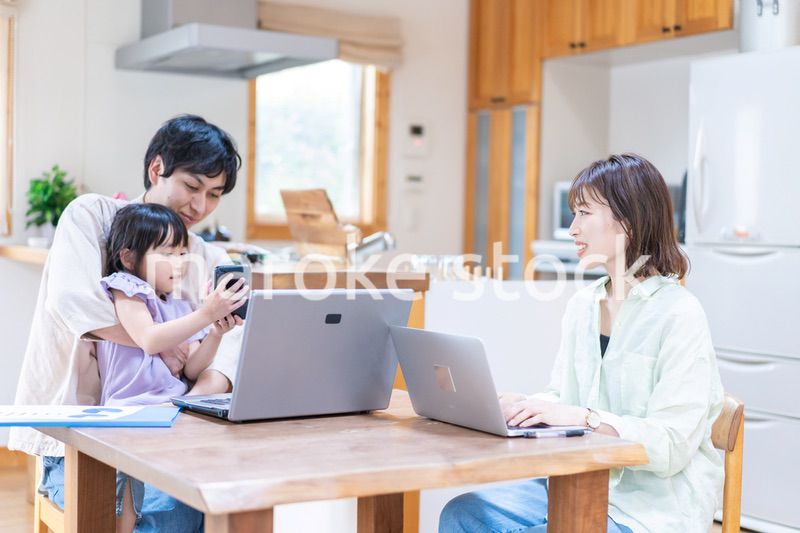 テレワークをする夫婦と子供