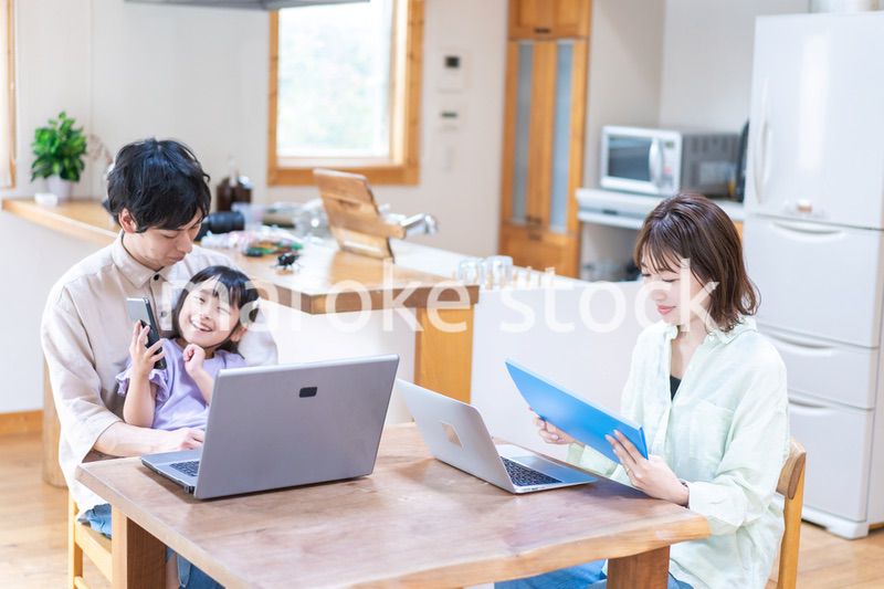 テレワークをする夫婦と子供
