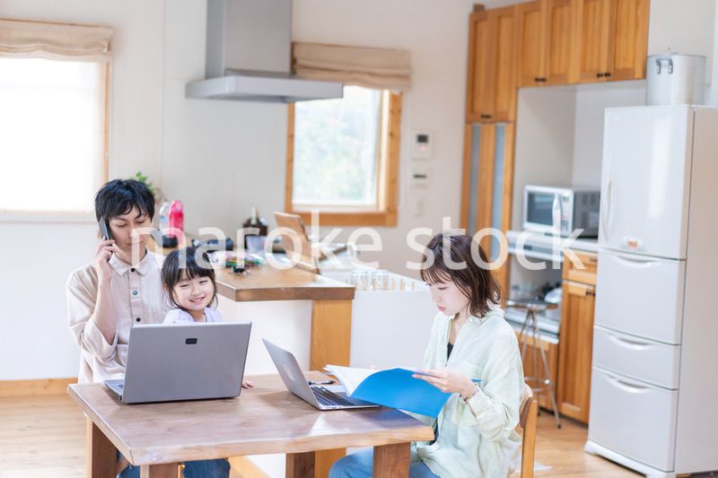 テレワークをする夫婦と子供