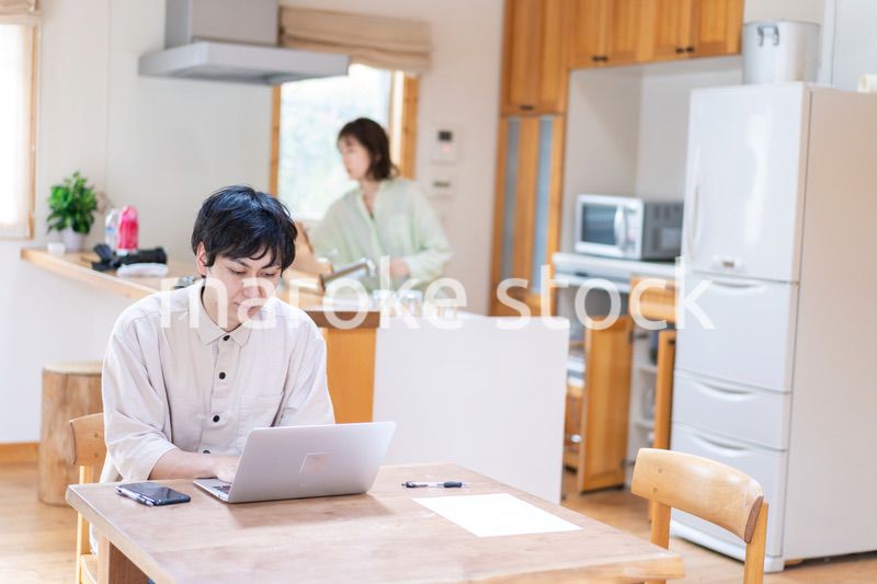 テレワークをする夫婦と子供