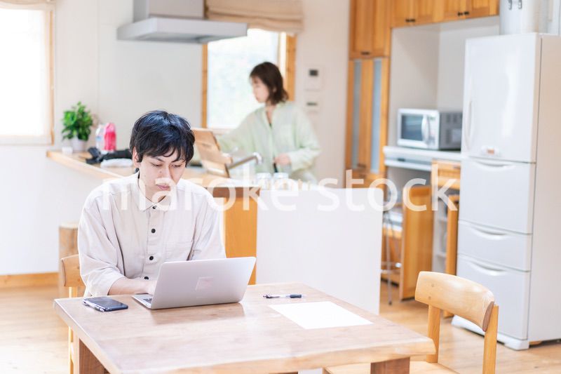 テレワークをする夫婦と子供