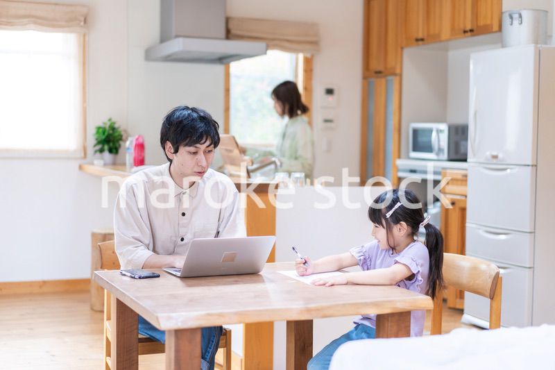 テレワークをする夫婦と子供