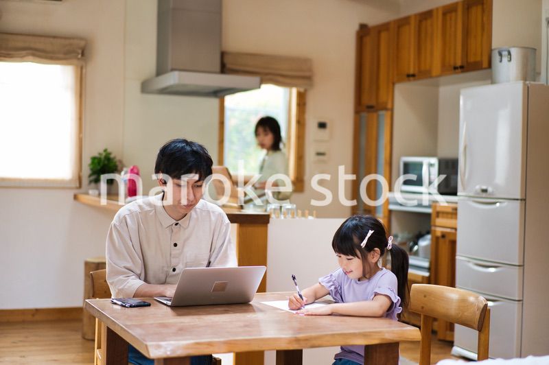 テレワークをする大人と家にいる子ども