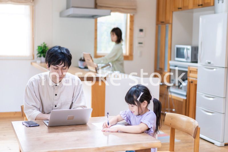 テレワークをする夫婦と子供