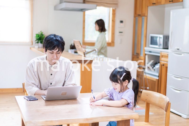 テレワークをする夫婦と子供